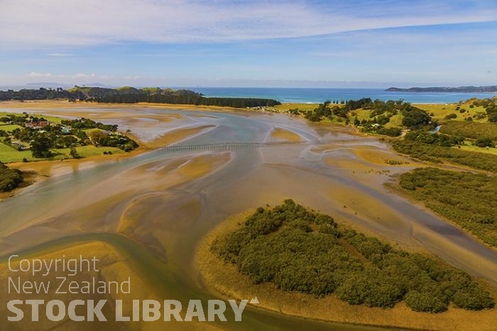 Whananaki North & South;Northland;sandy beaches;bachs;holiday homes;bush;native forrest;golden sands;blue sky;blue sea;Northland;golden beach;seaside town;Tutukaka coast;Sandy Bay:bach;baches;river estury;Pedestrian causway